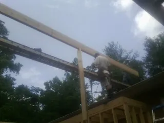 Carpenter setting a ridge beam over a new addition frame — Ice Dam Removal by Roofing Brothers in West Union