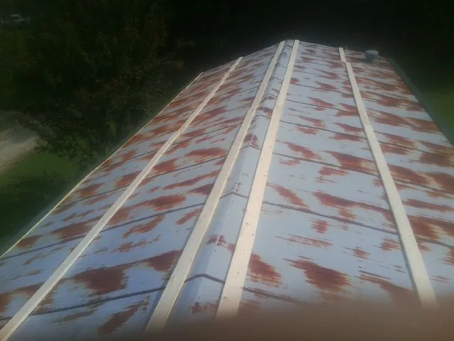 Rusted metal roof panels with new wood purlins before replacement — Storm Damage Roof Repair in West Union by Roofing Brothers